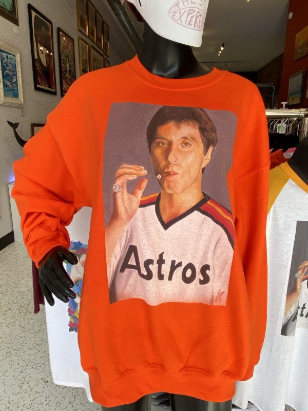 Scarface in a Astros jersey on a orange sweatshirt